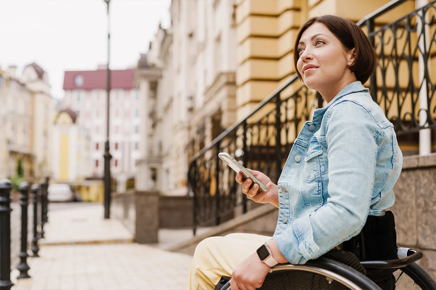 Brunette woman using mobile phone while sitting in wheelchair.