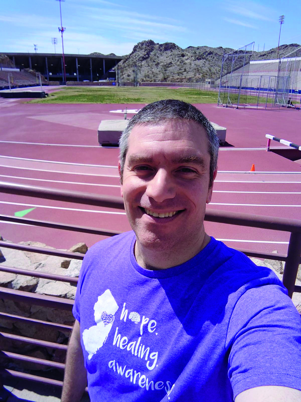 man smiling on running track