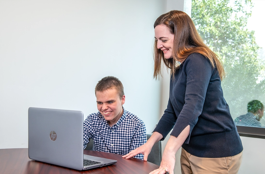 Two individuals collaborating at a desk 