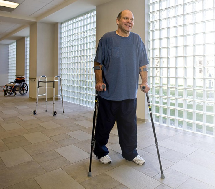 Participant walks with crutches, leaving his walker and wheelchair behind 