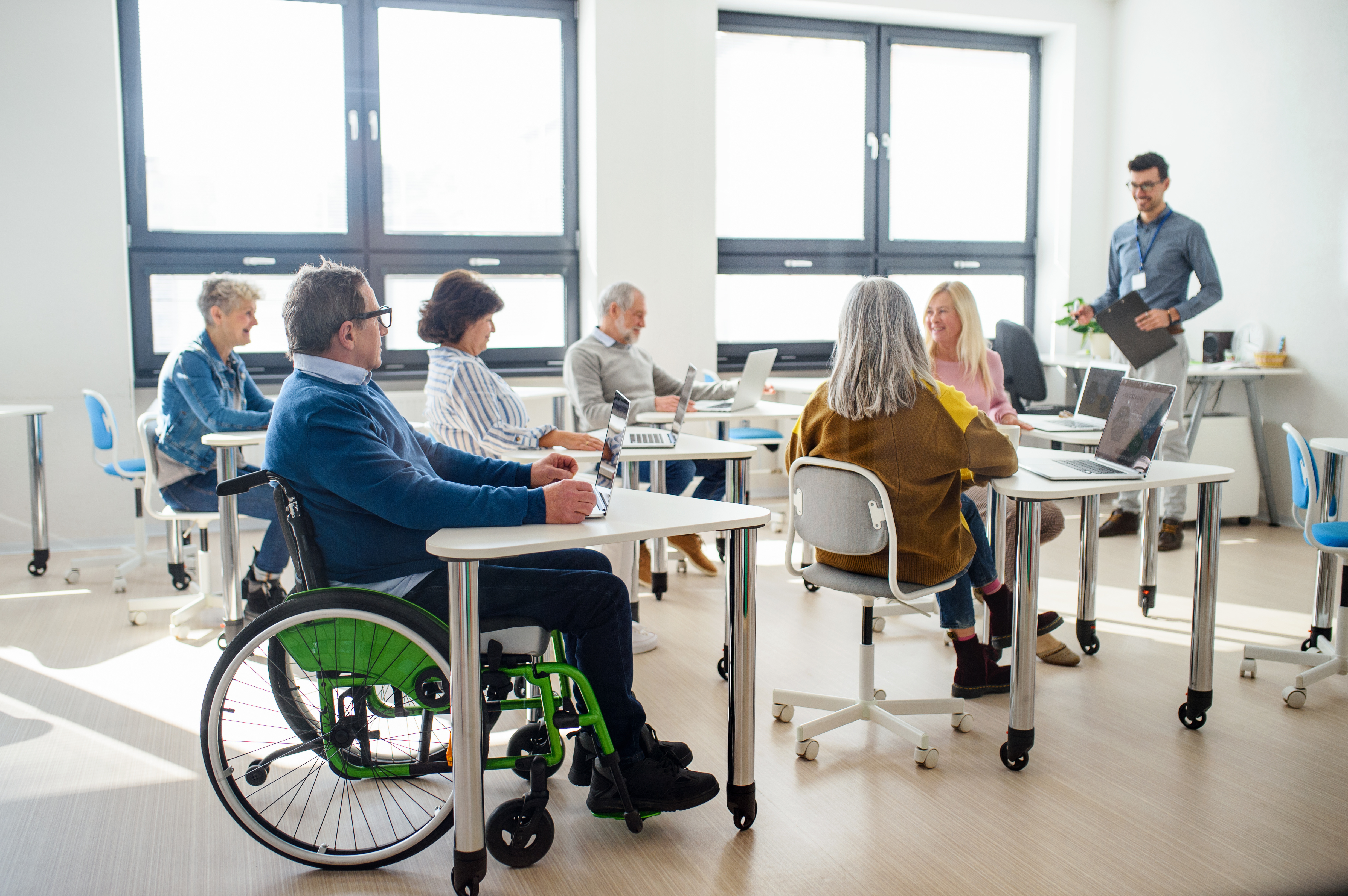man sitting in wheelchair in a classroom