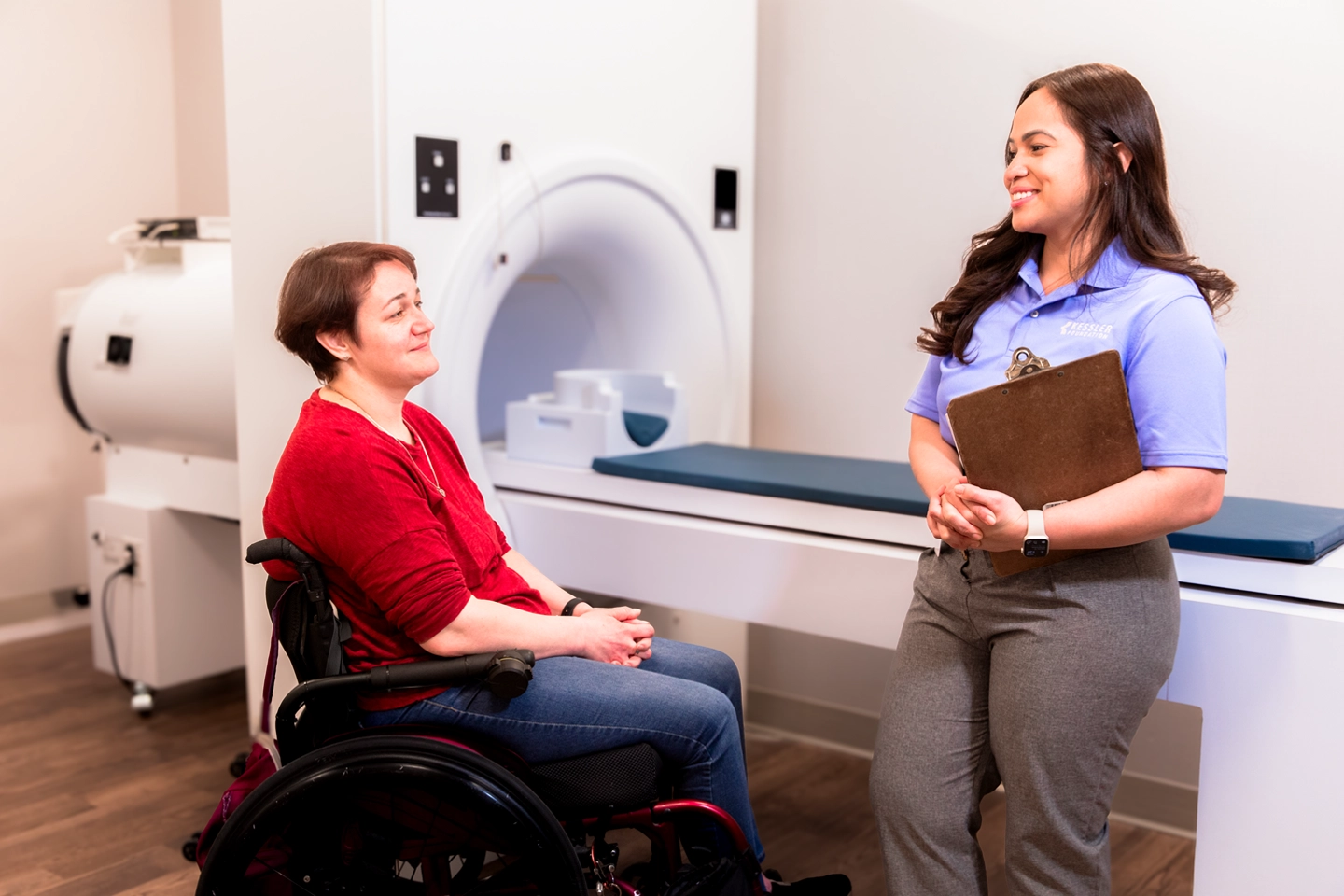 Participant and researcher in by the MRI machine while at a study session.