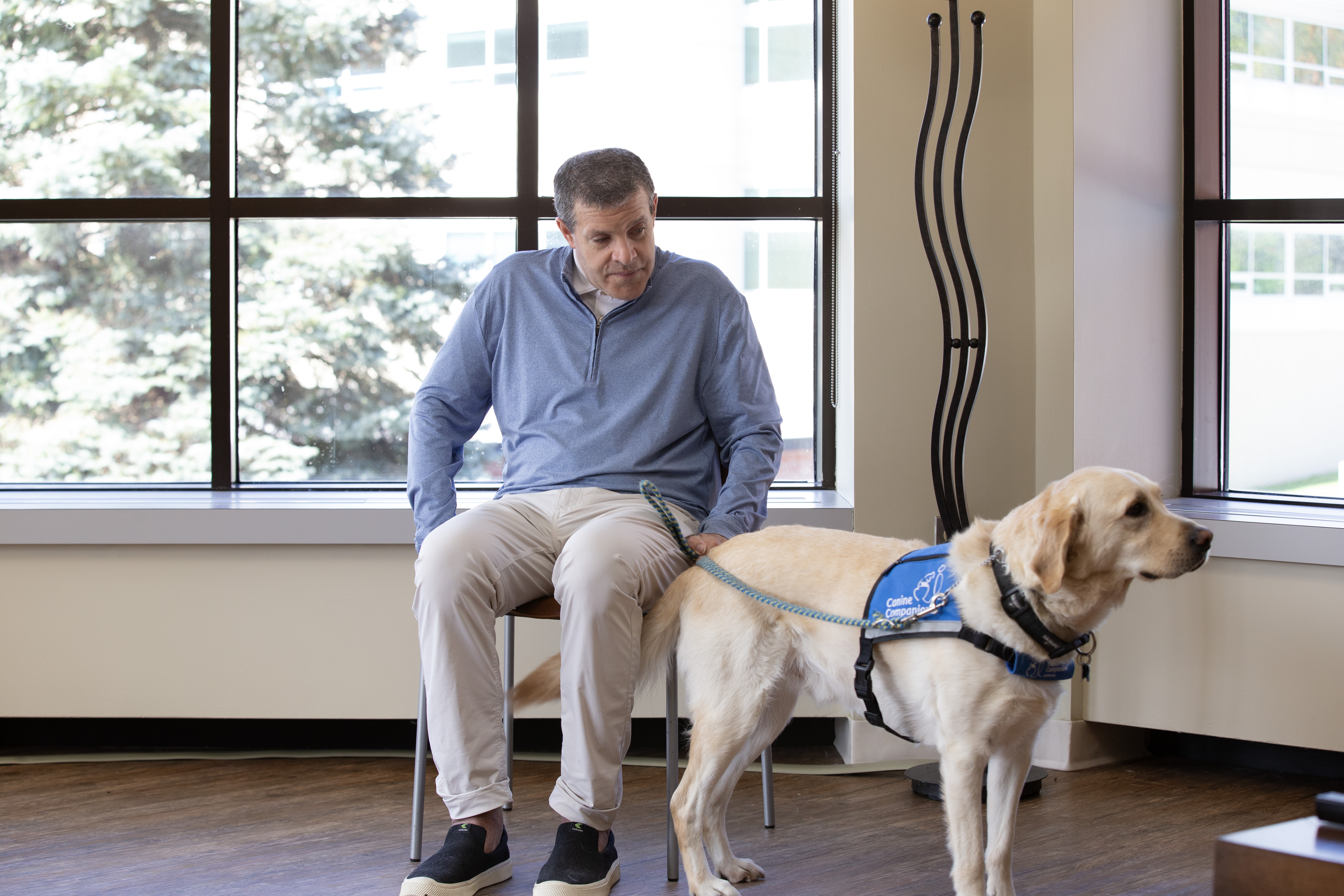 John McAleavey and his K9 companion sitting in a bright light filled room