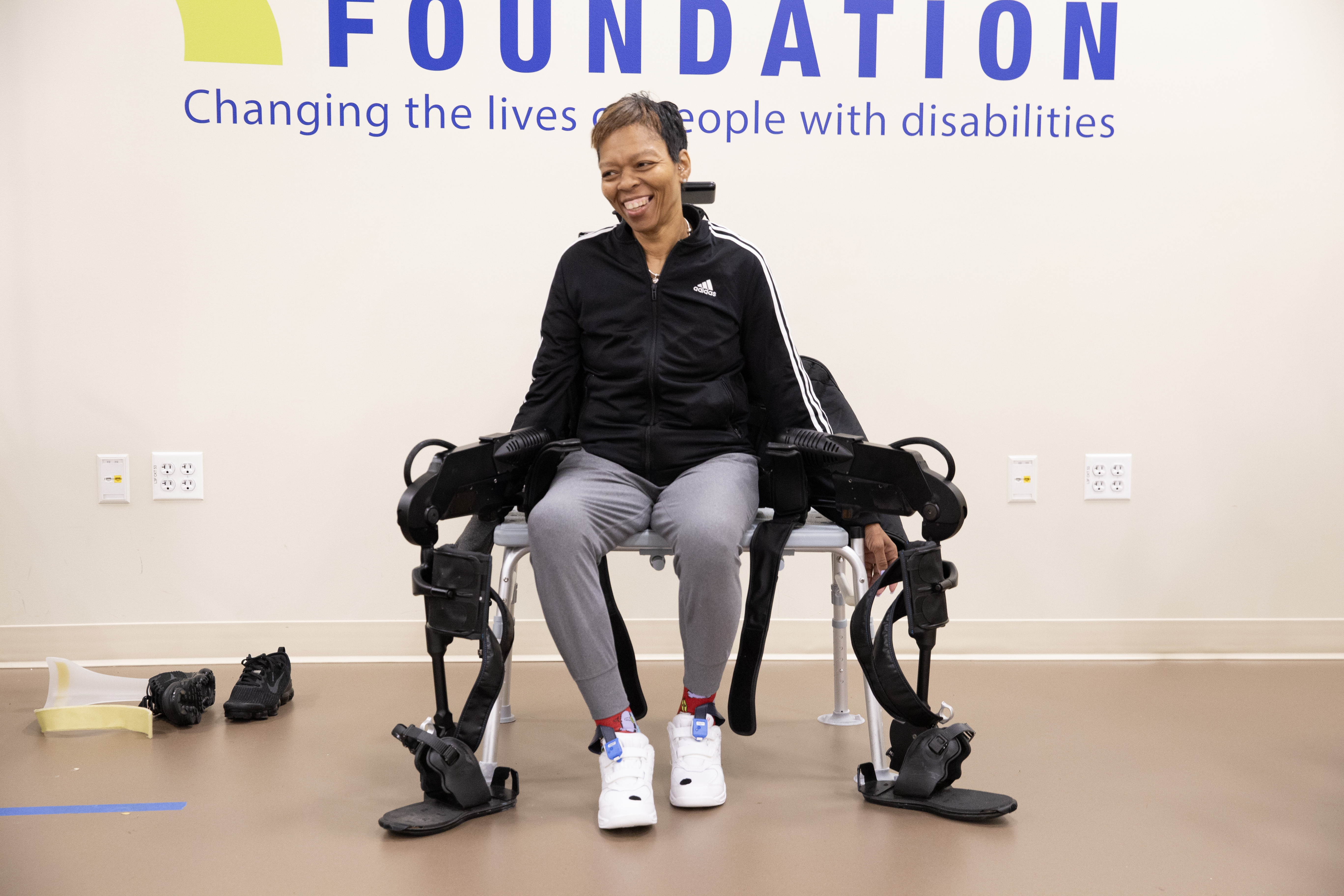 Woman sits on a bench with a robotic exoskeleton