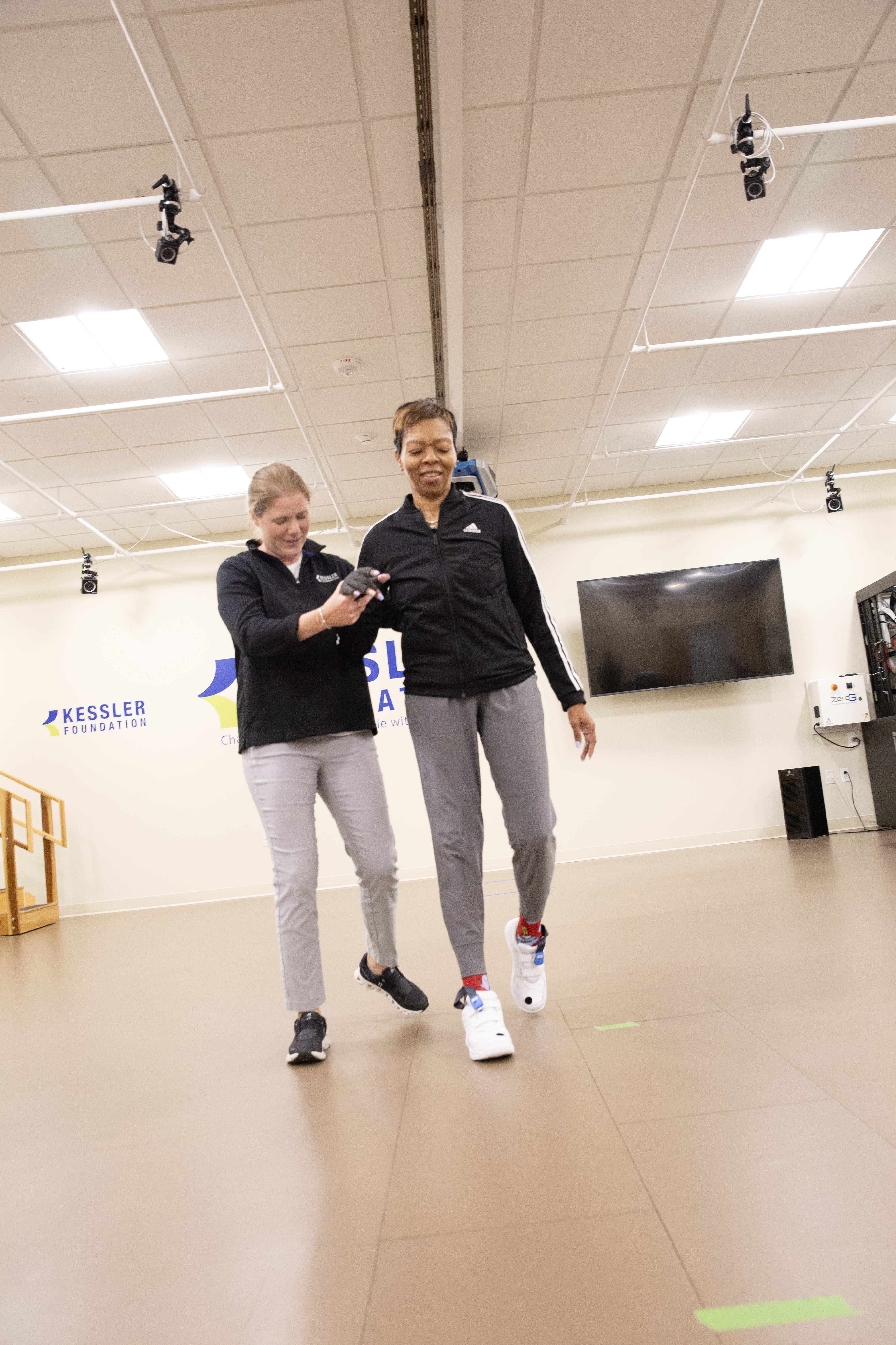Women walking in a rehabilitation setting with a physical therapist supporting her
