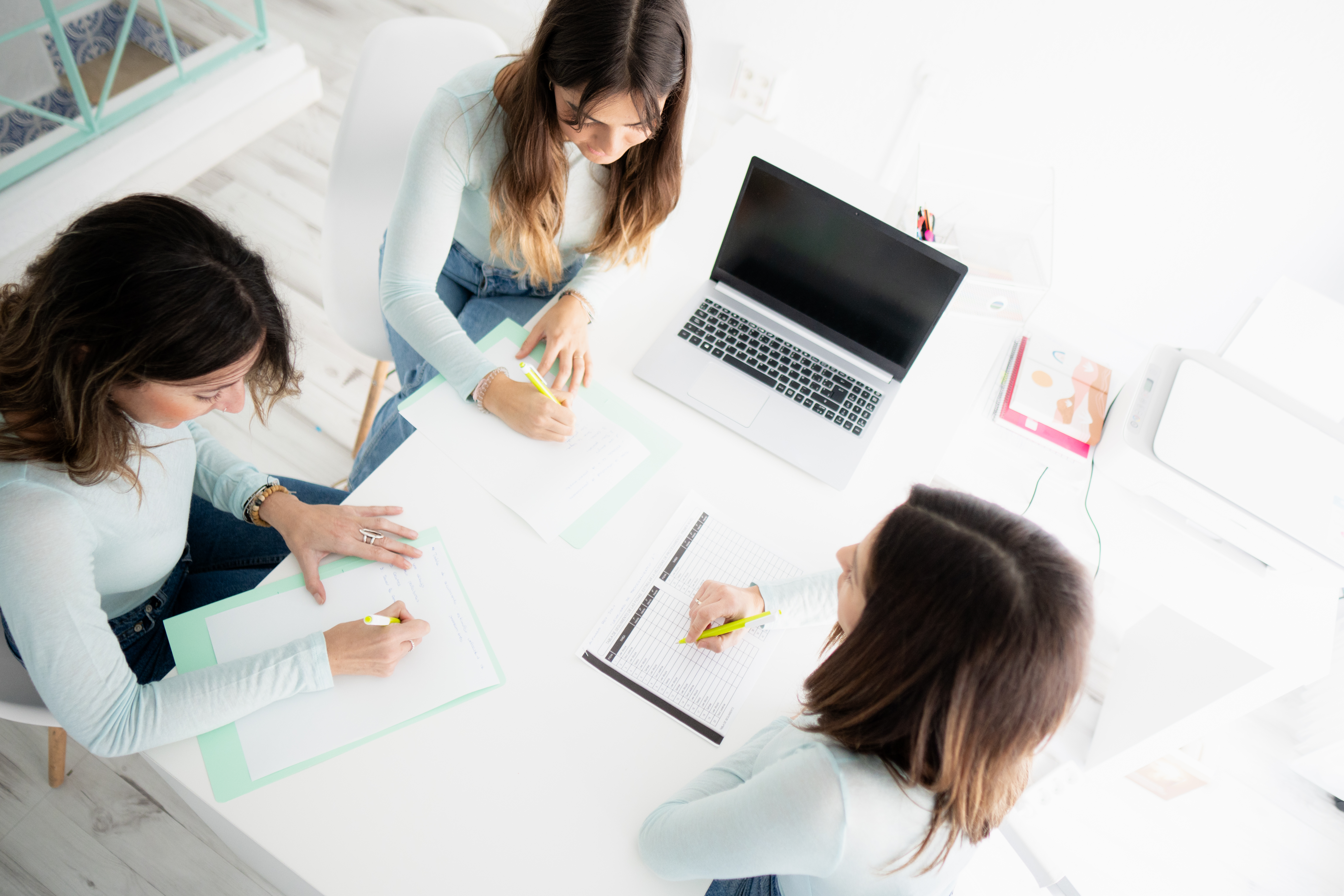 A group sits and works together at a conference table. 
