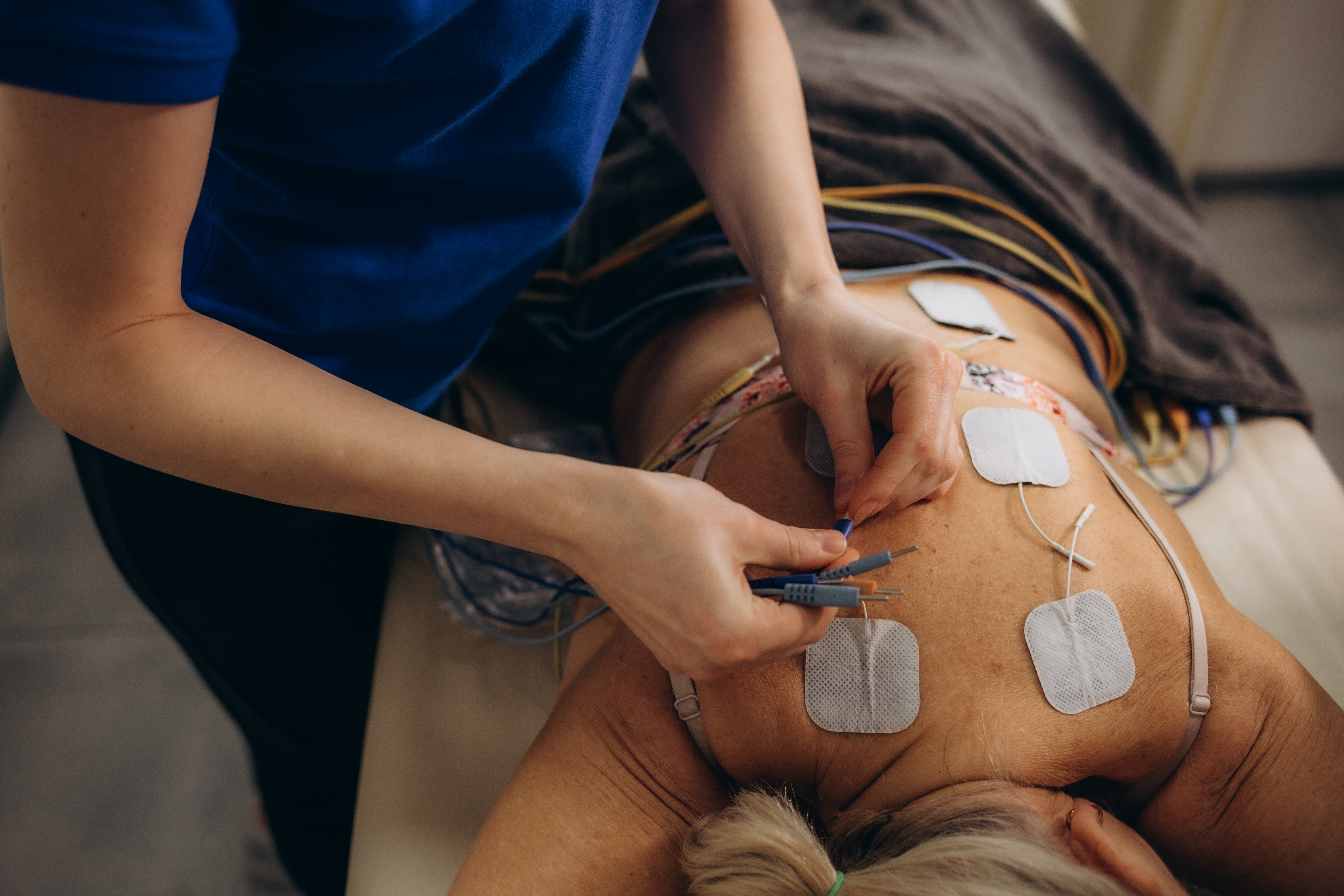 stimulation equipment is being places on a persons back