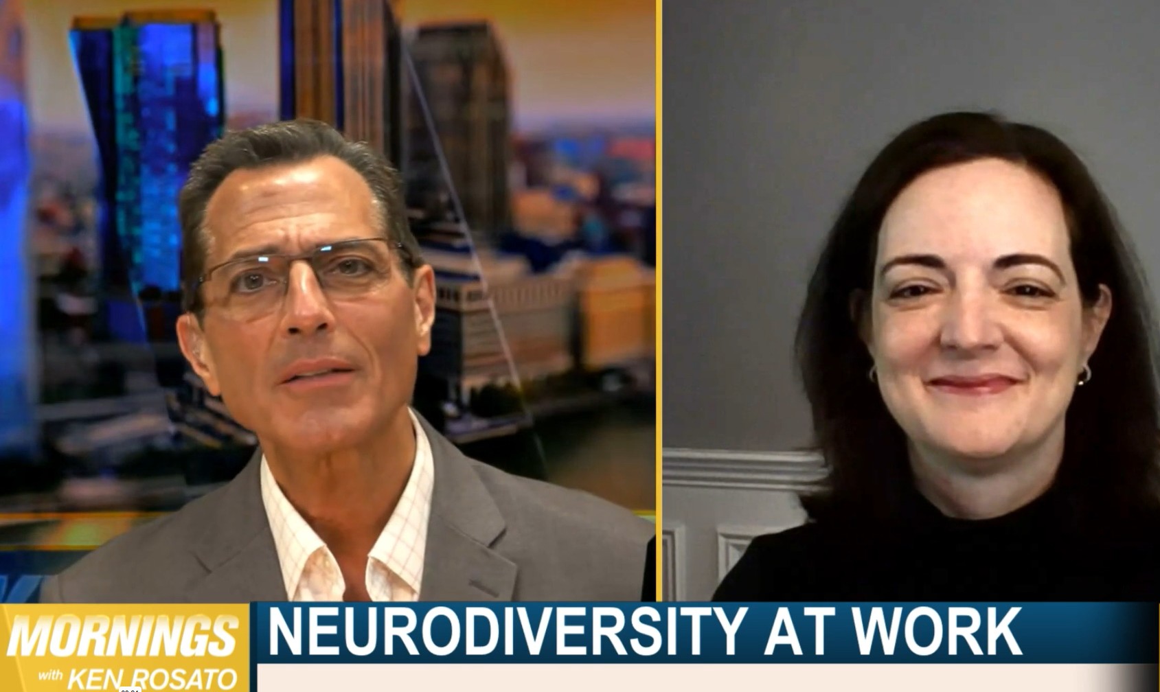 A man in a gray suit and glasses is interviewing a brunette woman wearing a black turtleneck about neurodiversity at work.