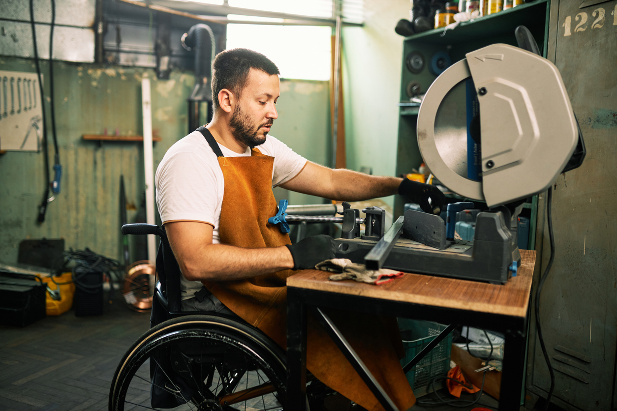 man in wheelchair working machinery 