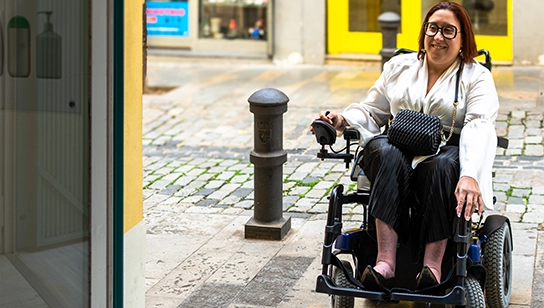 A women using a power wheelchair using the ramp to get on a public bus
