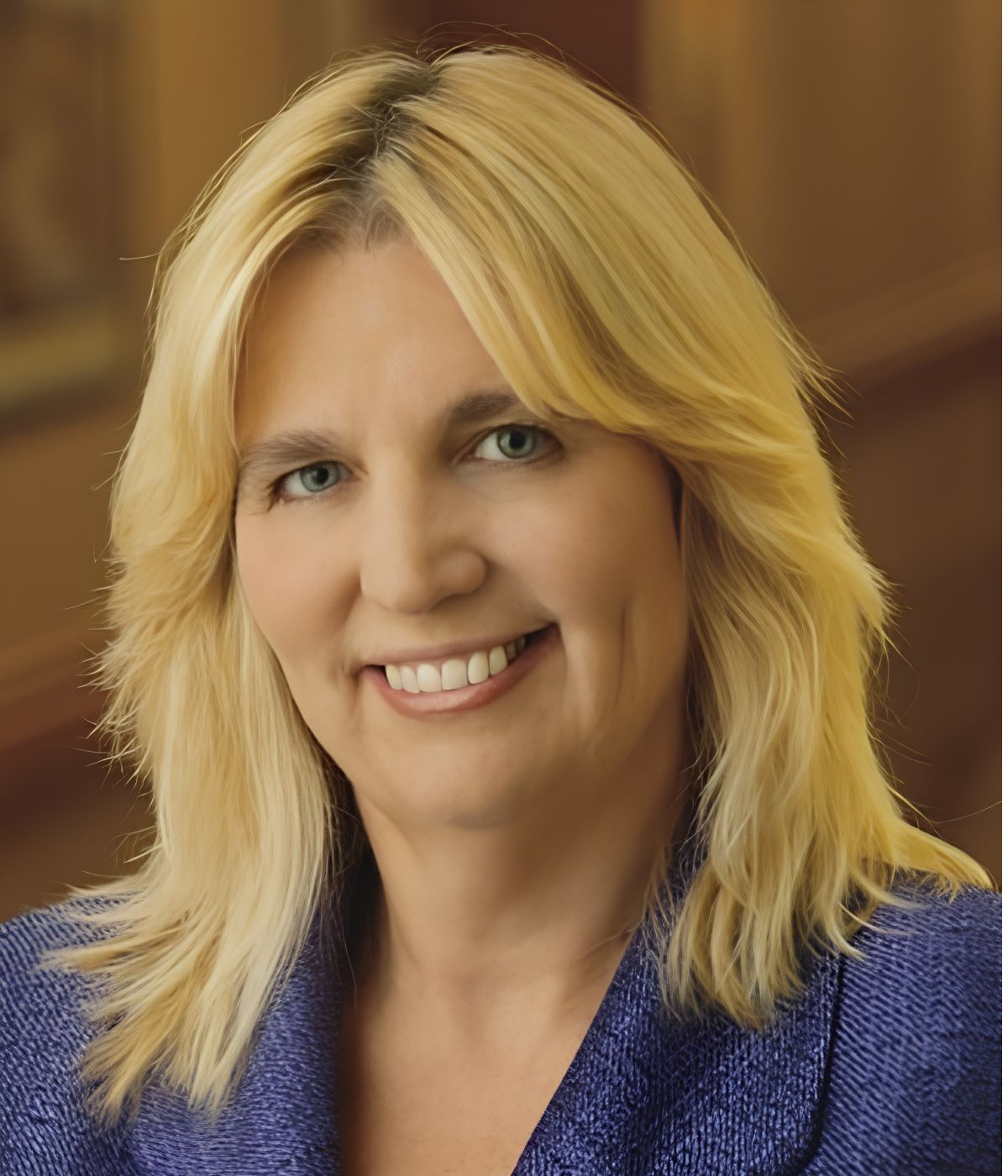 Image of a smiling woman with blonde hair and a blue blazer.