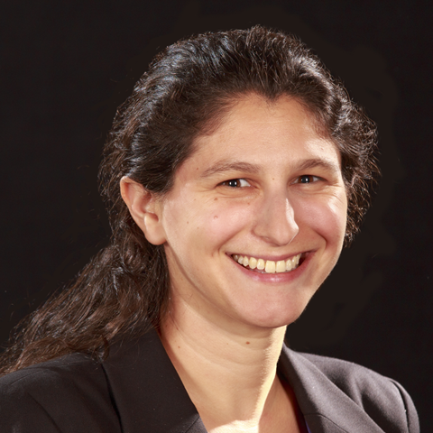 Woman wearing dark jacket with long dark hair smiling