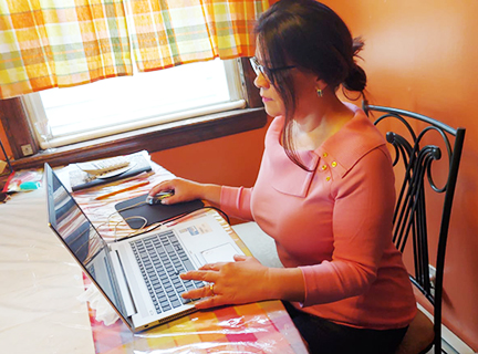 Jenny Masmela, sitting in front of a computer  