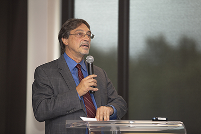 A man standing at a podium and speaking into a microphone 