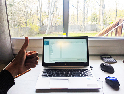 Photo of a thumbs-up next to a computer