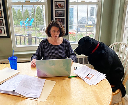 Nancy Chiaravalloti, sitting next to her dog while working from home