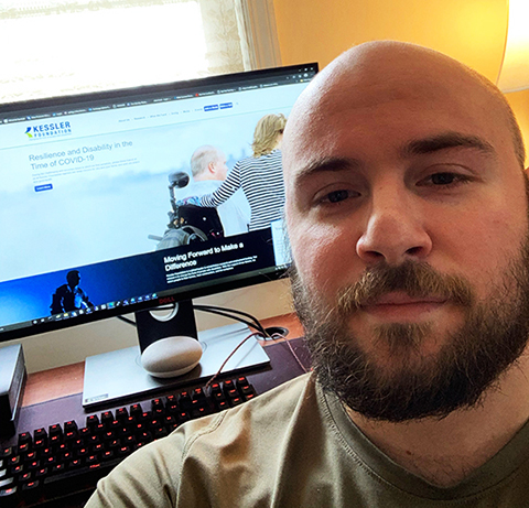 Nicholas Piombo, sitting at his desk, next to a computer 