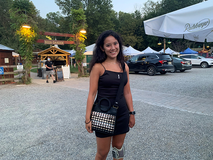 A woman standing outdoors with a sparkly handbag 