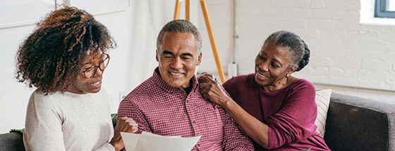 black man and two black women looking at a paper 