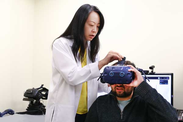 Female researcher scientist with a participant wearing special goggles