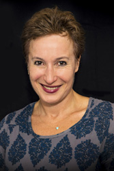 head shot of a woman against a black background 