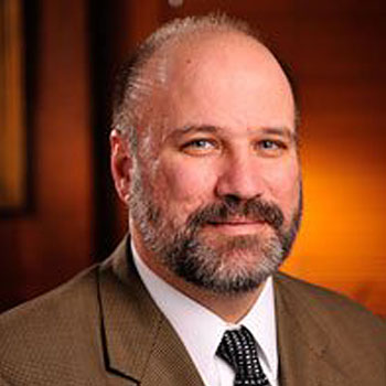 Man with a beard and brown office jacket