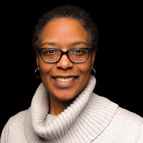 Black woman with eyeglasses and wearing white turtle neck