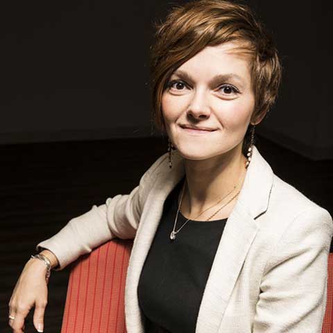 female scientist wearing a beige jacket with a black blouse