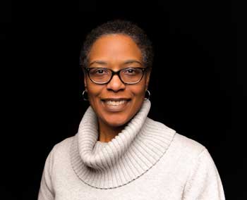 headshot photograph of a female scientist researcher with eyeglasses and white sweater
