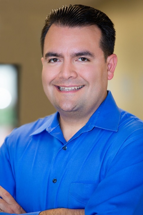 Image of Dr. Kirk Lercher. He is smiling and wearing a royal blue button up shirt.