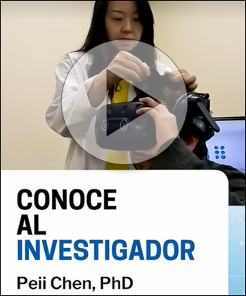 Female scientist with a participant wearing goggle with spanish text