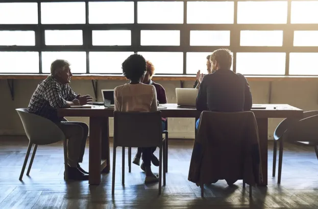 Staff gathered around a table having a meeting