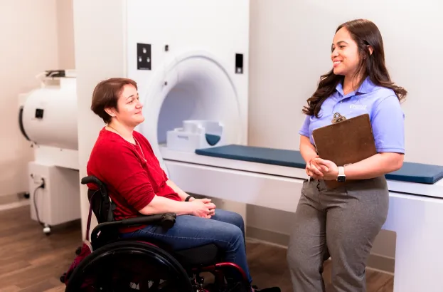 Participant and researcher in by the MRI machine while at a study session.