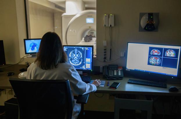 Researcher in the MRI control room during a research session scan.