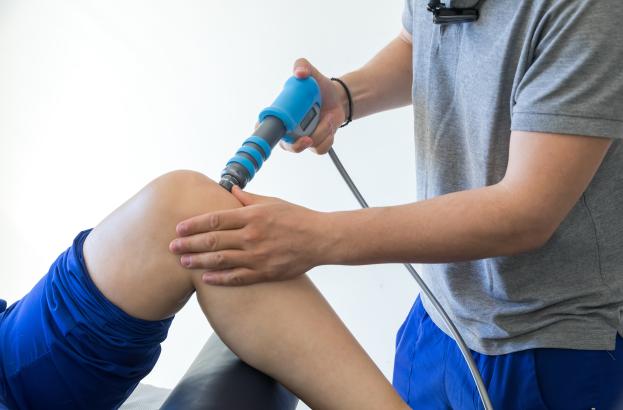 Clinician and patient completing ESWT of the knee