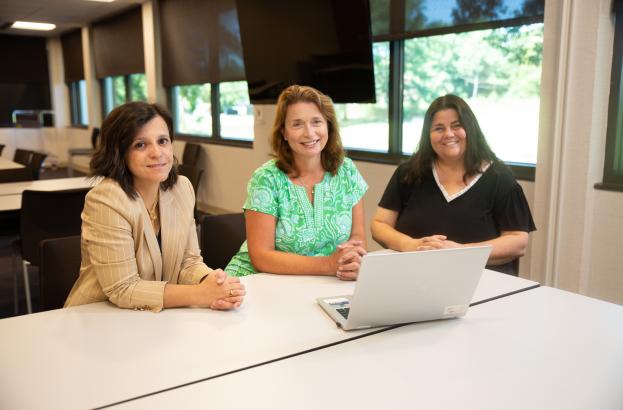 three women seated in a conference room