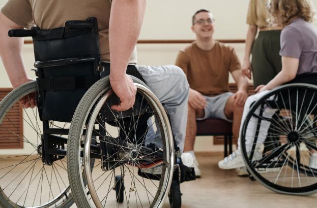 A group of wheelchair users gather together in conversaton
