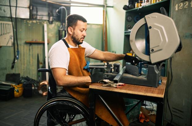 man in wheelchair working machinery 