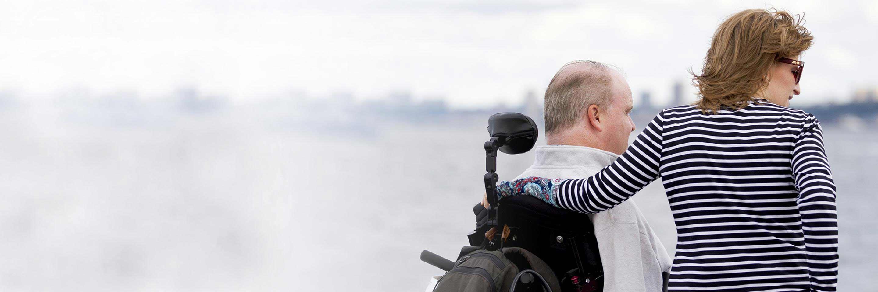 Henry on wheelchair and Mary's arm around her