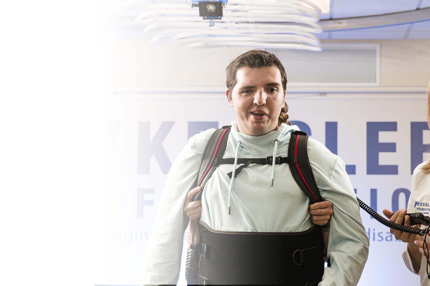 Participant in Ekso suit with Dr standing near by