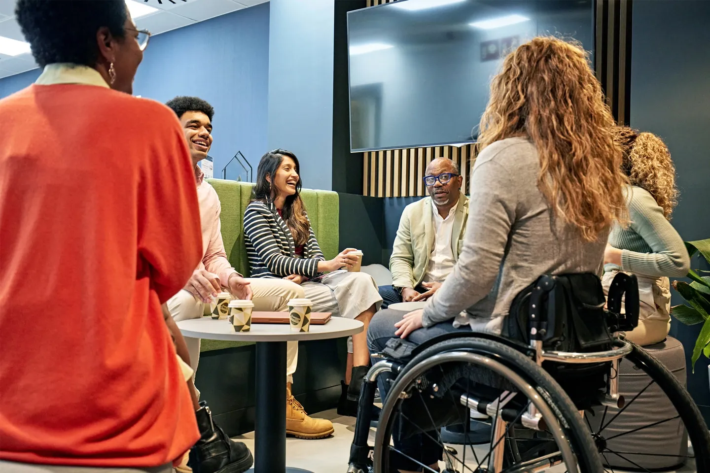 image of a woman in a wheelchair seating at a table with some friend