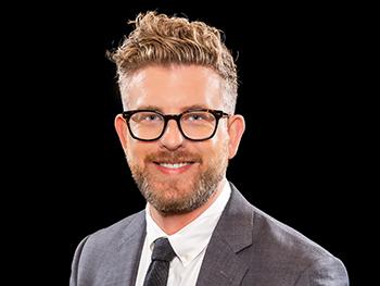 Headshot of Timothy Rich on black background