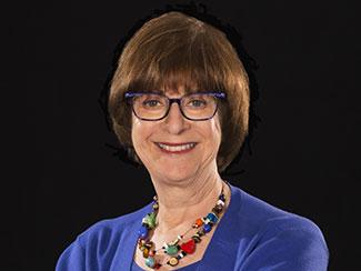 Lady with blue blouse and eyeglasses smiling