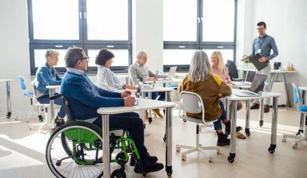 man sitting in wheelchair in a classroom
