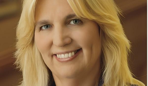 Image of a smiling woman with blonde hair and a blue blazer.