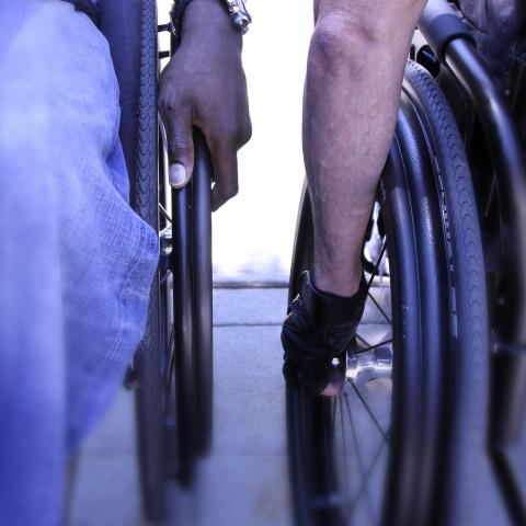 Hands rolling wheelchairs 