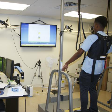 Two people in a science lab testing out balance equipment  