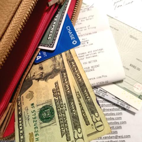 Photo of a purse and money and receipts scattered 