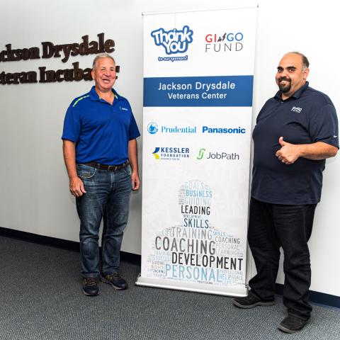 GI GO Fund members standing next to Jackson Drysdale sign