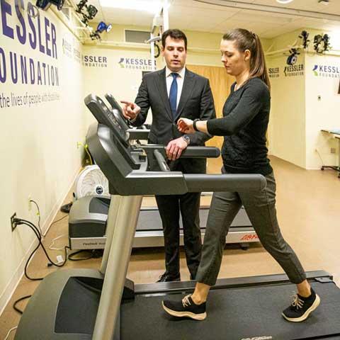 man speaking to a woman on a treadmill